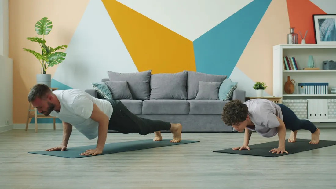 Coureur faisant du renforcement au sol dans un salon, tapis et petits accessoires visibles